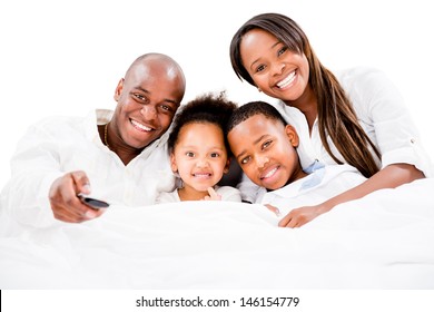 Happy family watching tv in bed - isolated over white 