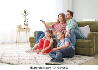 Happy family watching TV at home - Shutterstock ID 1473540653