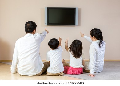 Happy Family Watching TV At Home