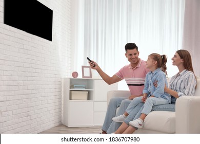 Happy Family Watching TV On Sofa At Home