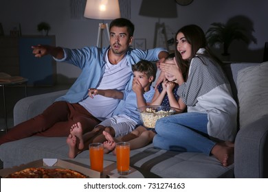 Happy Family Watching TV On Sofa At Night