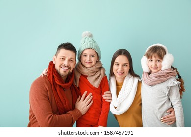 Happy Family In Winter Clothes On Color Background