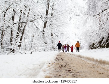 Happy Family Winter Fun Outdoors. Active Parents With Kids Running In Snowy Forest