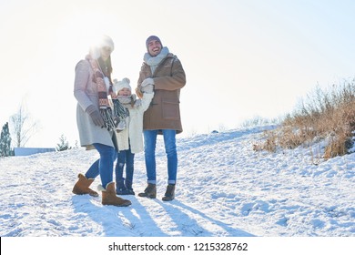 Happy Family In Winter Holiday Trip With Child Playing With Snow