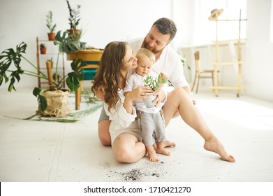 Happy Family Working At Home. Transplanting Plants With Their Child