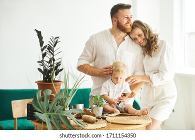 Happy family working at home. Transplanting plants with their child - Powered by Shutterstock