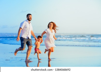 Happy family - young father, mother, baby son run together, child jump with fun by water pool along sunset sea surf on tropical beach. Travel lifestyle, people walking with kid on summer vacation - Powered by Shutterstock