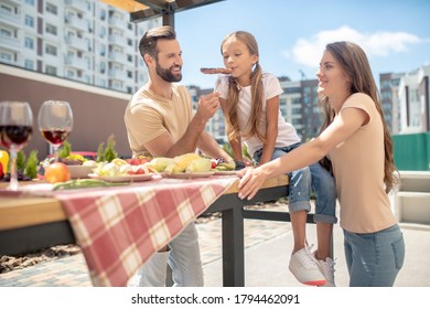 Happy Family. Young Family Having Dinner Outside And Looking Enjoyed