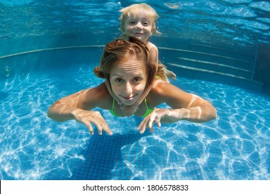 Happy Family - Young Mother, Baby Boy Learn To Swim, Dive Underwater. Jump With Fun In Swimming Pool. Healthy Lifestyle, Active Parents, People Water Sports Activities On Summer Holidays With Kids.