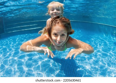 Happy family - young mother, baby boy learn to swim, dive underwater. Jump with fun in swimming pool. Healthy lifestyle, active parents, people water sports activities on summer holidays with kids. - Shutterstock ID 2205630461