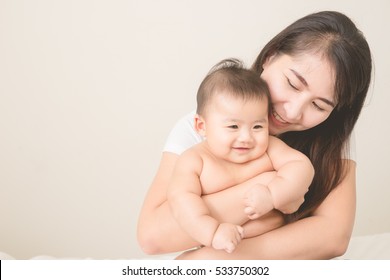 Happy Family.asian  Mother Playing With Her Baby In The Bedroom.