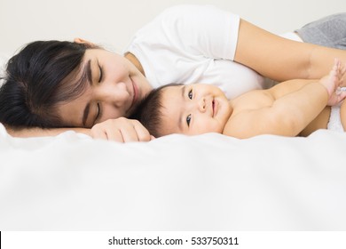 Happy Family.asian  Mother Playing With Her Baby In The Bedroom.