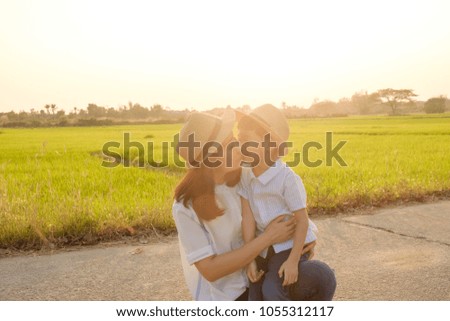 Happy fammily.A son kiss his mother in grass fields outdoors at evening.Vacation and holiday concept with copy space