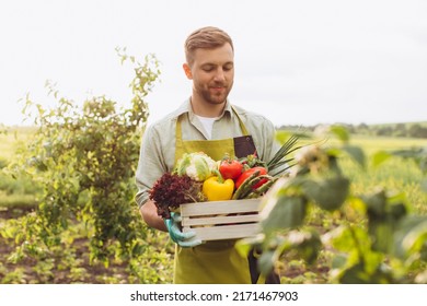 Happy farmer man holding basket with fresh vegetables in garden, gardening concept - Shutterstock ID 2171467903