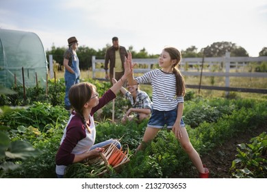 Happy Farmers Or Gardeners Working Outdoors At Community Farm.