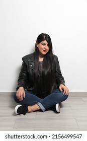 Happy, Fat And Proud Latin Young Adult Woman Shows Her Long Straight, Black And Shiny Hair On A White Background With A Leather Jacket And Black Tennis Shoes	