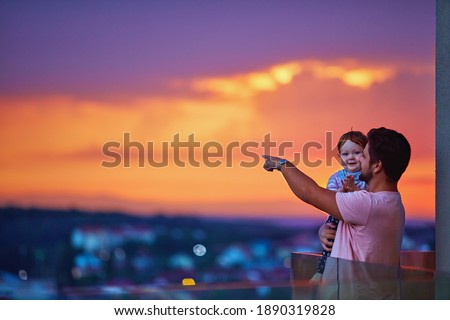 happy father and baby watching the city on sunset at the rooftop balcony with glass balustrade Сток-фото © 