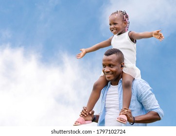 Happy Father Carrying Daughter On Shoulders, Cheerful African American Girl On The Shoulders Of His Father With Clipping Path