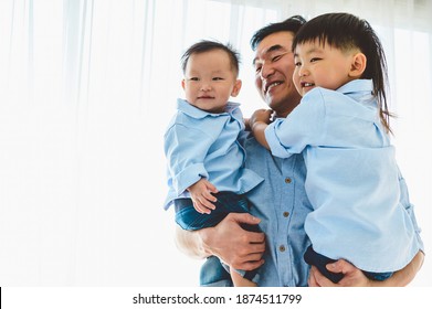 Happy Father Carrying Two Children In Bedroom At Their House. Family Living And Having Positive Expression Emotion Togetherness. Leisure Time. People Lifestyle Health. Quarantine Covid-19 Coranavirus