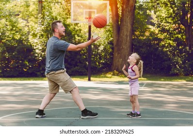 A Happy Father And Child Daughter Outside At Basketball Court.