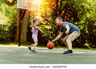 A Happy Father And Child Daughter Outside At Basketball Court.