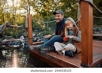 Happy father with daughter fishing by the lake in autumn. Copy space. - Powered by Shutterstock