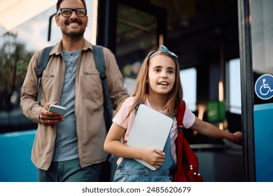 Happy father and daughter getting out off a bus at city station. Focus is on girl.  - Powered by Shutterstock