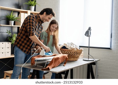 Happy father with daughter at home doing household chores and ironing together. - Powered by Shutterstock