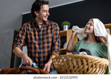 Happy father with daughter at home doing household chores and ironing together. - Powered by Shutterstock