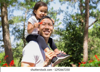 Happy Father And Daughter Playing In The Park Outside.