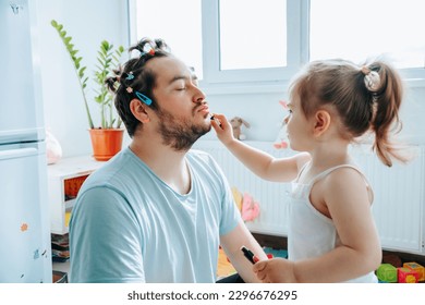 happy father and daughter spending quality time together, with the dad helping his child put on makeup and sharing a laugh. Ultimate Makeover When a Dad Decides to Try Putting Makeup on His Kid - Powered by Shutterstock