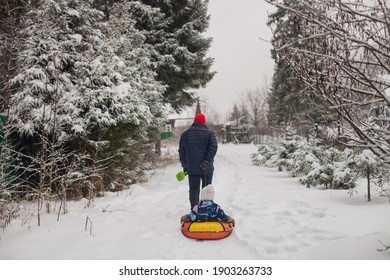 Happy father and daugther sledging together in winter park