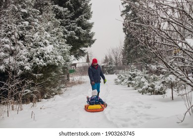Happy father and daugther sledging together in winter park