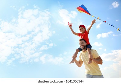 Happy father and his child playing with kite on sunny day. Spending time in nature - Powered by Shutterstock