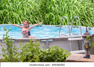 Happy Father And His Cute Little Five Year Old Daughter In An Above Ground Swimming Pool Laughing And Smiling