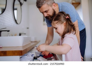 Happy Father With His Little Daughter In Bathroom, Morning Routine Concept.