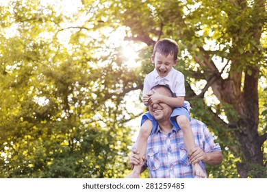 Happy Father With His Son Spending Time Together Outside In Green Nature.