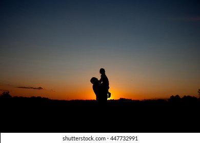 Happy Father holding baby on sunset