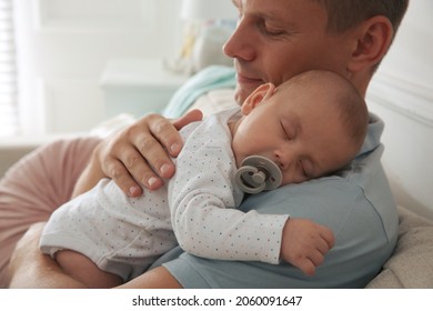 Happy father holding his cute sleeping baby with pacifier at home - Powered by Shutterstock