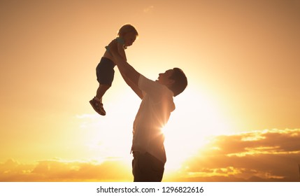 Happy Father Holding His Son Up In The Air