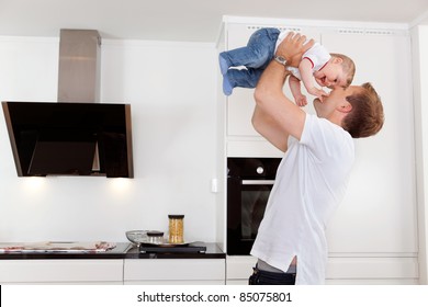 Happy Father Holding His Young Child Up