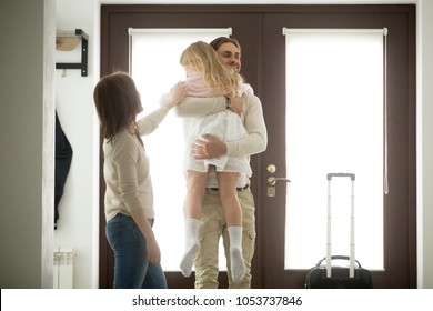 Happy father hugging little daughter arriving returning after long trip, smiling dad holding kid girl in arms embracing child standing in house hall, welcome back home daddy or family reunion concept - Powered by Shutterstock