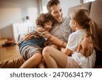 Happy father hugging two kids at home