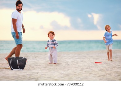 Happy Father With Kids, Family Playing Flying Disc Golf On Evening Beach