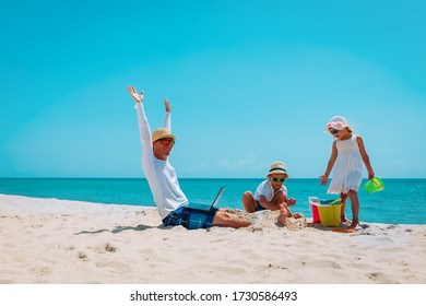 Happy Father With Laptop Trying To Work And Kids Play With Sand On Beach