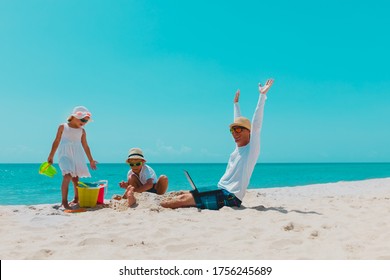 Happy Father With Laptop Trying To Work And Kids Play With Sand On Beach