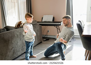 A Happy father and little son having fun together in living room play air guitar - Powered by Shutterstock