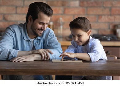 Happy Father With Little Son Playing Checkers At Home Together, Family Spending Leisure Time, Caring Smiling Young Dad And 8s Boy Kid Engaged In Funny Educational Activity, Wooden Board Game