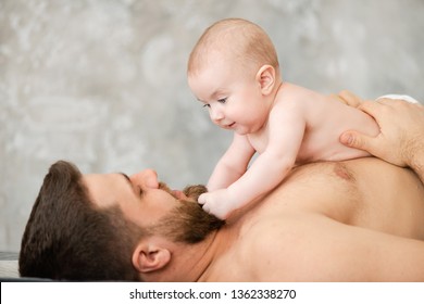 Happy Father Lying With Baby Girl On His Chest