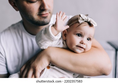 Happy Father Lying On Sofa Holding Baby Girl, Playing, Smiling. Side View.